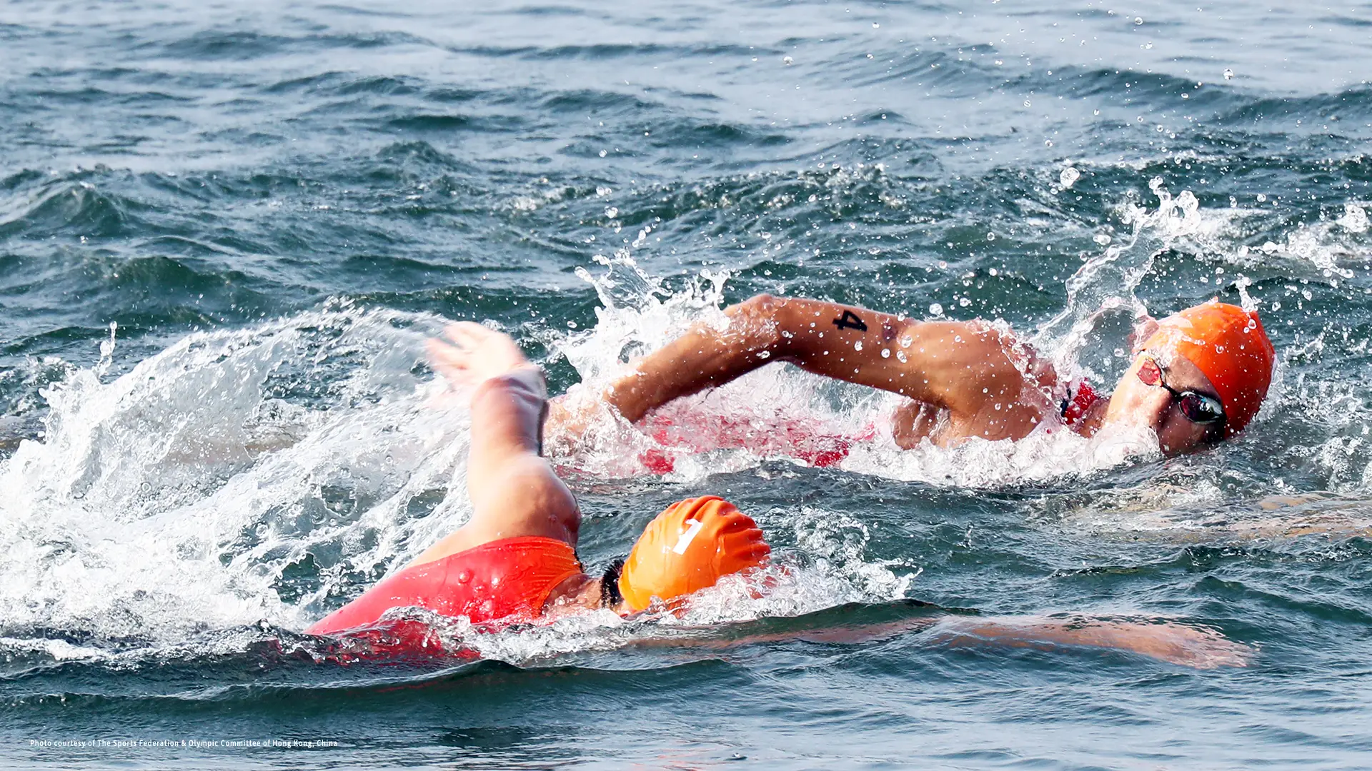Two swimmers competing in a triathlon.